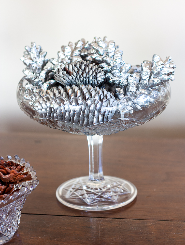 Pinecones painted silver in an antique glass compote