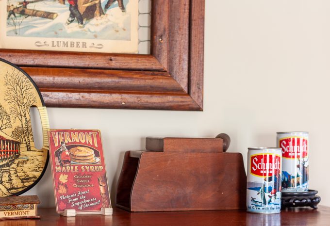 Vintage wood pipe and tobacco holder, 1970s Schmidt beer cans, and a wood Vermont maple syrup postcard