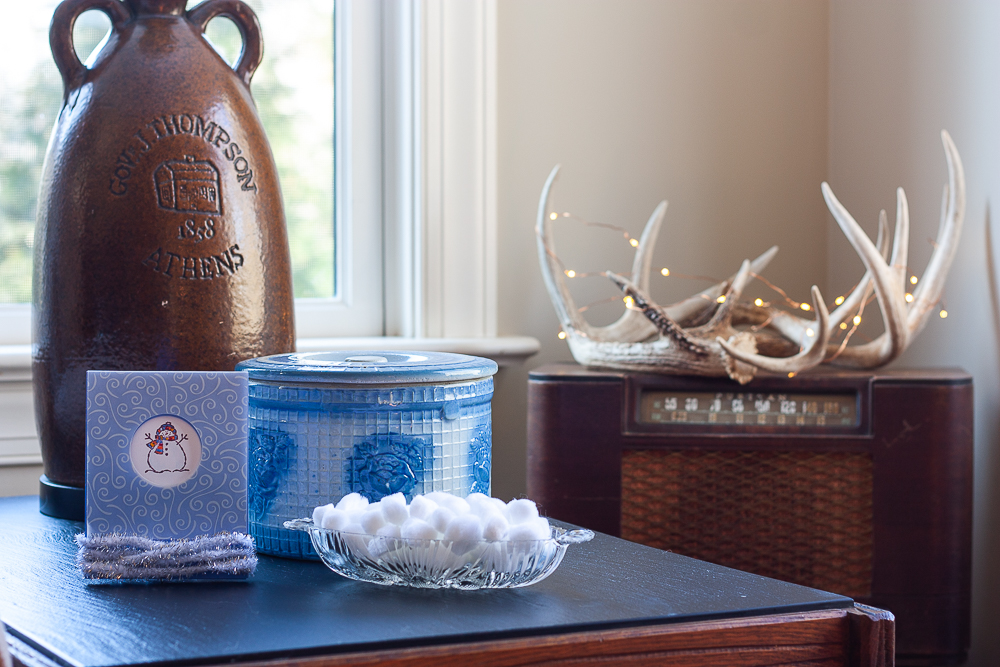 Stamped snowman card, antique blue crock, white pom-poms in a glass bowl