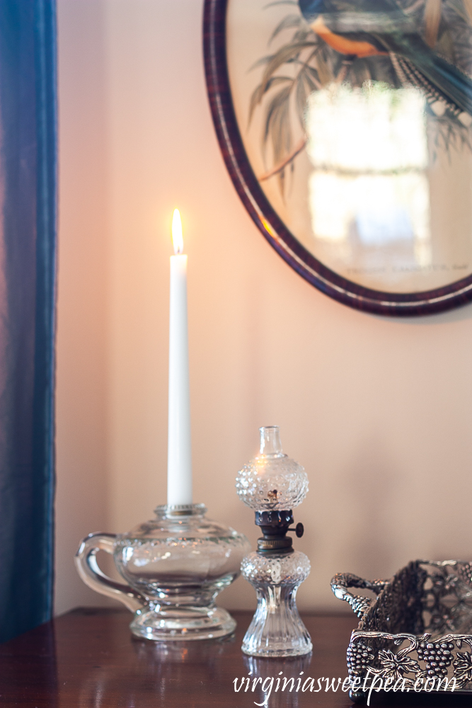 Antique oil lamp used as a candle holder with a mini glass antique lamp