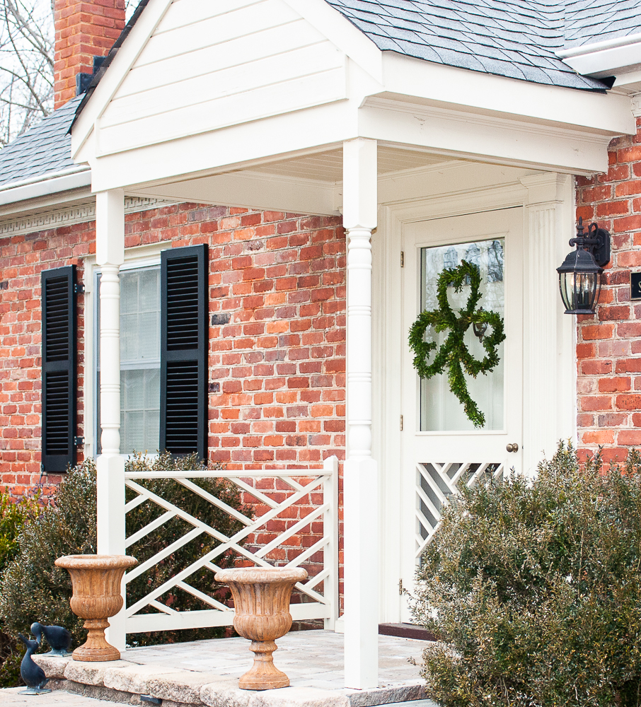 Front door decorated for March with a Boxwood covered clover shaped wreath