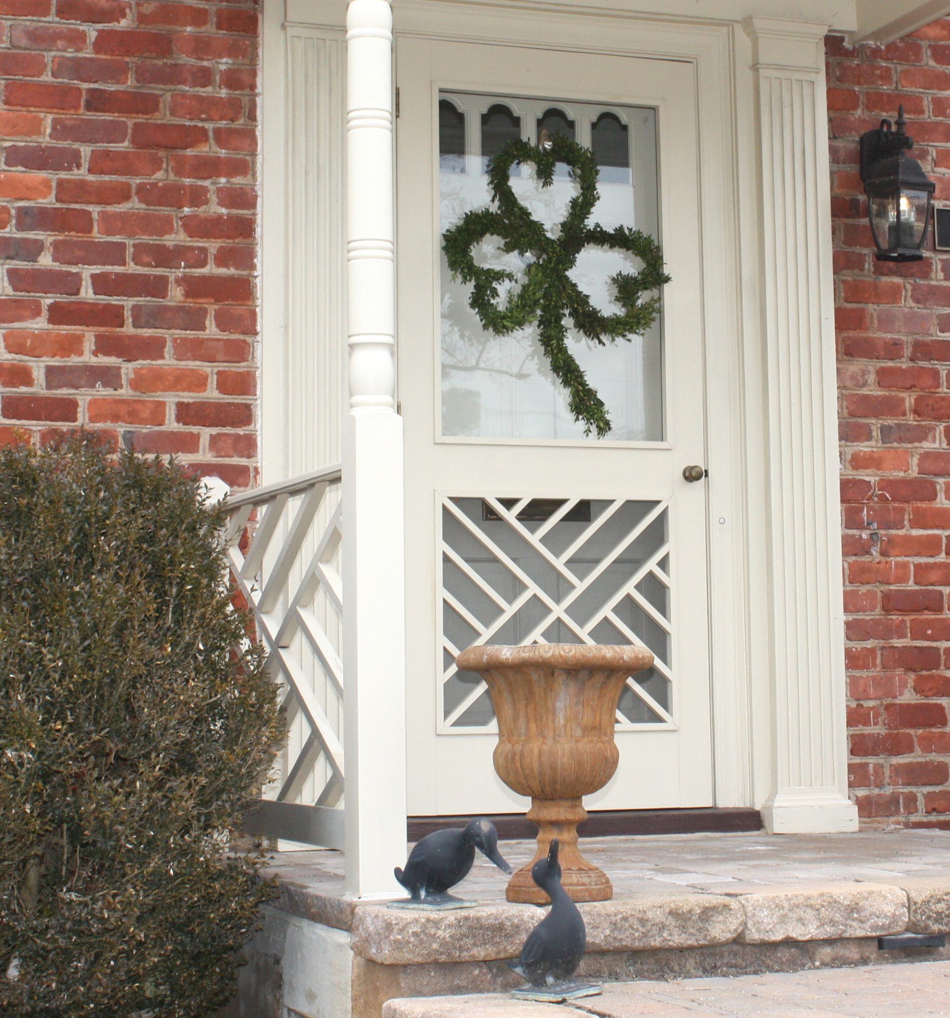 Front door decorated with a Shamrock shaped Boxwood wreath