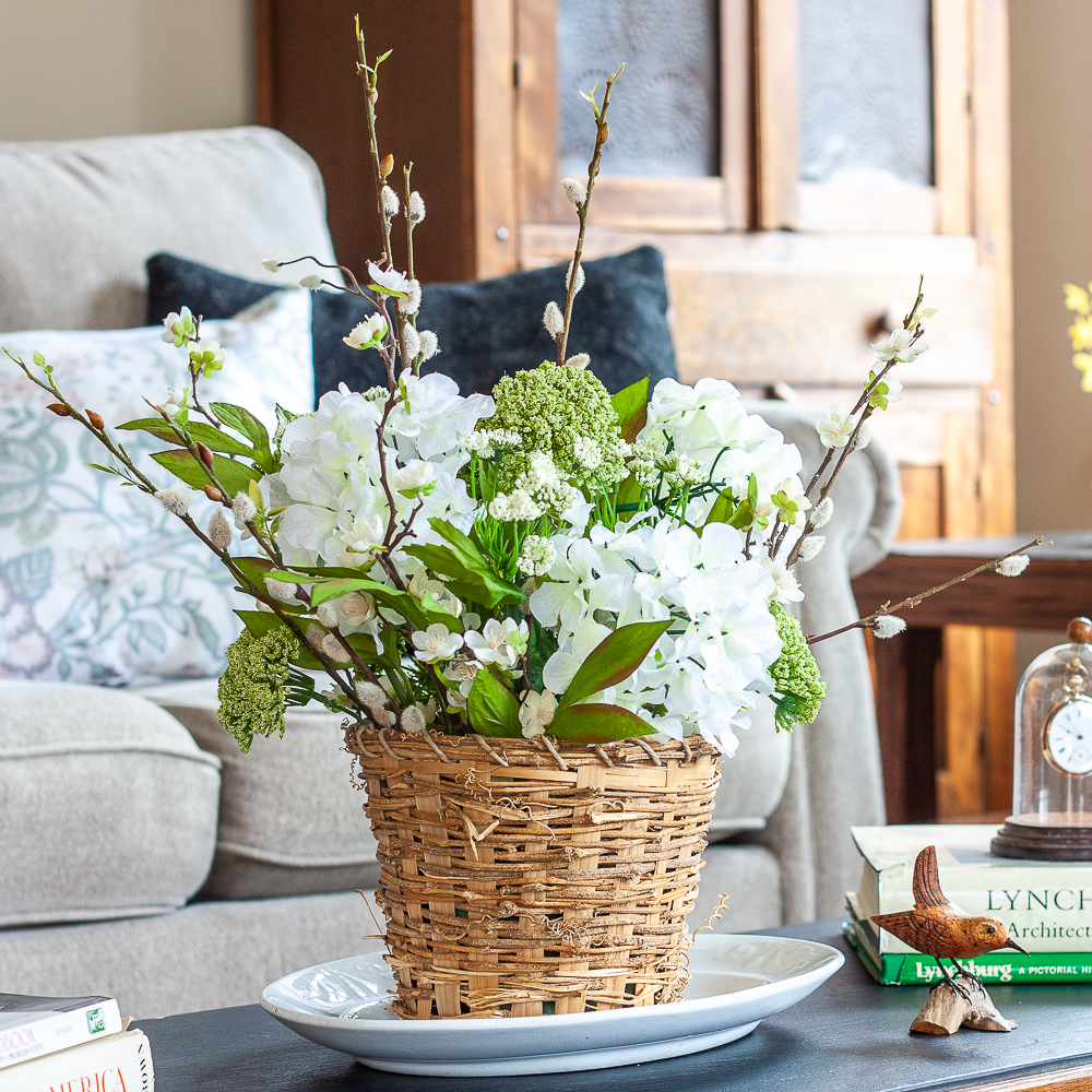 Spring flower arrangement sitting on an Ironstone platter on a slate 1960s coffee table