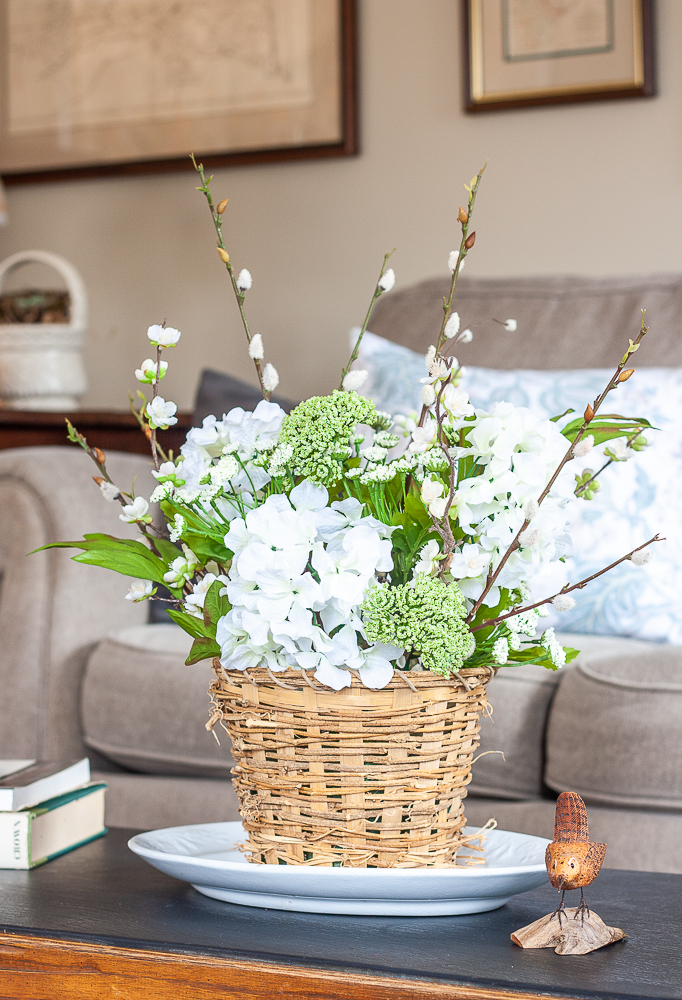 Spring flower arrangement in a woven basket on an Ironstone platter