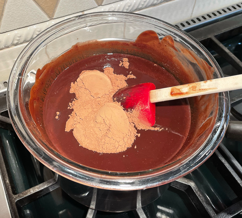 Adding cocoa powder to melted semisweet and bitterweet chocolate with melted butter