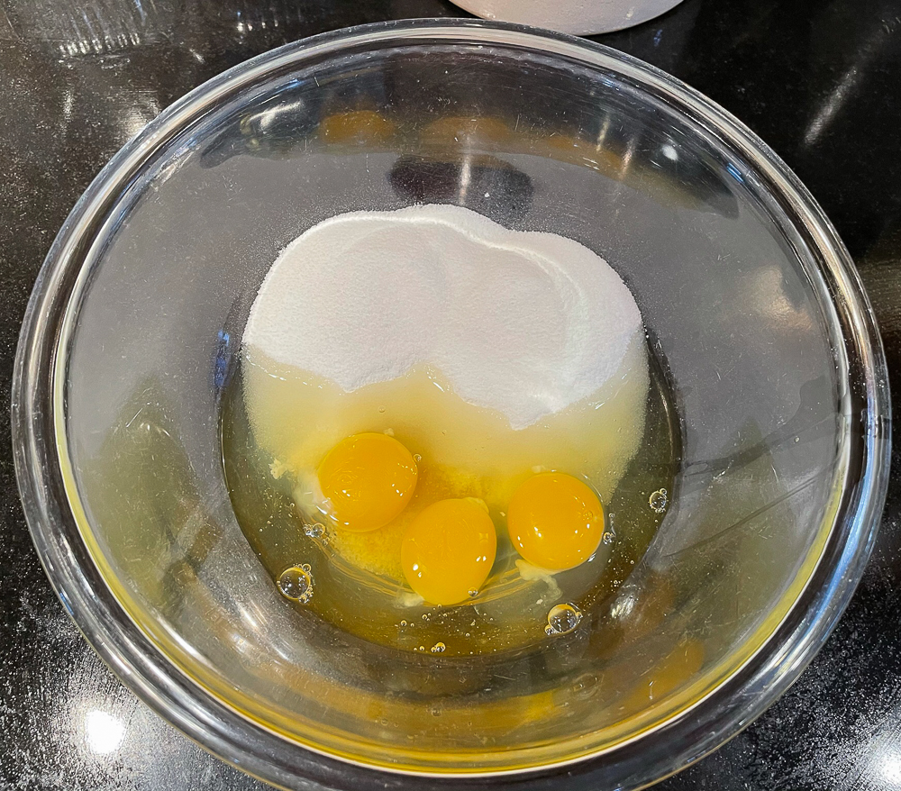 Eggs, sugar, vanilla in a glass bowl