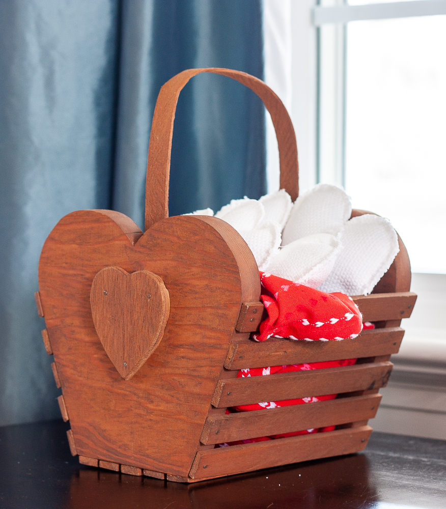 Handmade 1980s wood slat basket with a heart filled with handmade white hearts and a red dish towel with hearts