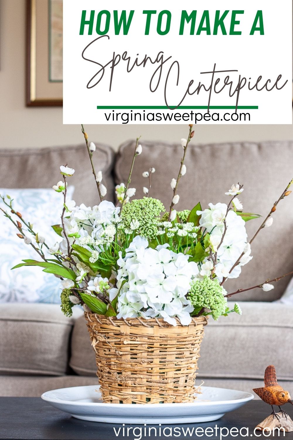 Spring table centerpiece in a woven basket with hydrangea, pussy willow, and other flower branches and blooms.