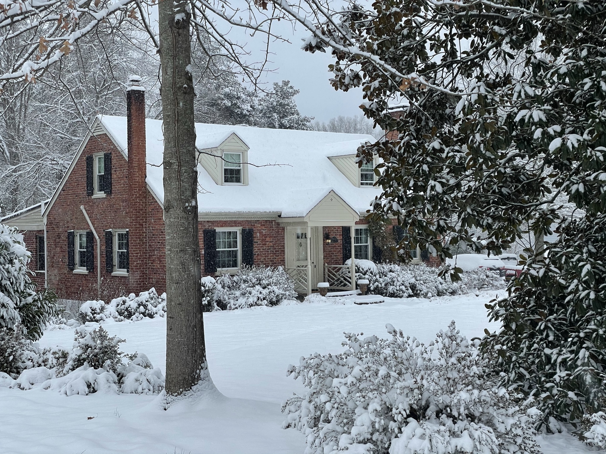 1950s brick cape cod with snow