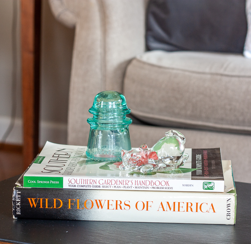 1953 Wild Flowers of America book by H.W. Rickett illustrated by Mary Vaux Walcott displayed with a Southern Gardener's Handbook by Troy Marden, a 1980s glass cat, and a Lynchburg, VA blue insulator manufactured by the Lynchburg Glass Cooperation between 1923 and 1925.