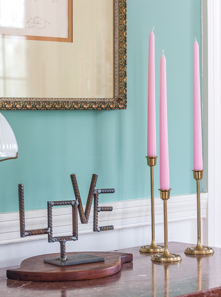 Handmade welded Love sign with trio of brass candlesticks with pink candles