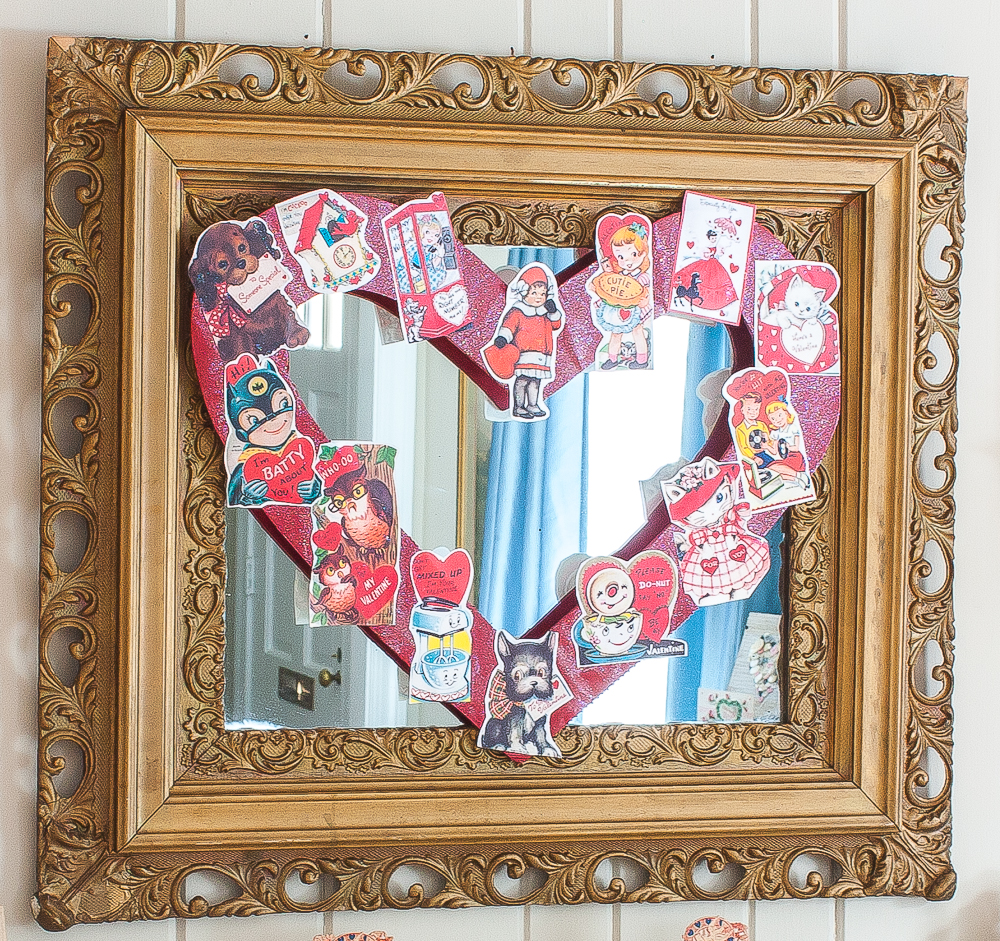 Antique gold mirror with a Valentine's Day wreath decorated with vintage Valentine's Day cards