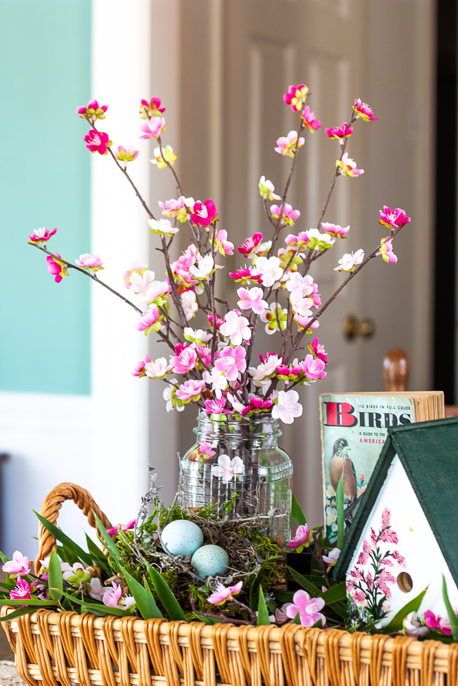 Handmade bird house with a 1949 Birds Golden Nature Guide and pink flowers in a clear, embossed Mason Jar