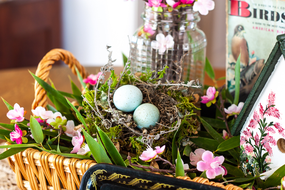 Handmade bird house with a 1949 Birds Golden Nature Guide, birds nest, and pink flowers in a clear, embossed Mason jar