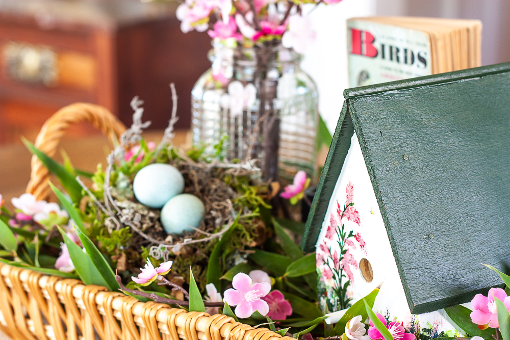 Handmade bird house with a 1949 Birds Golden Nature Guide, birds nest, and pink flowers in a clear, embossed Mason jar