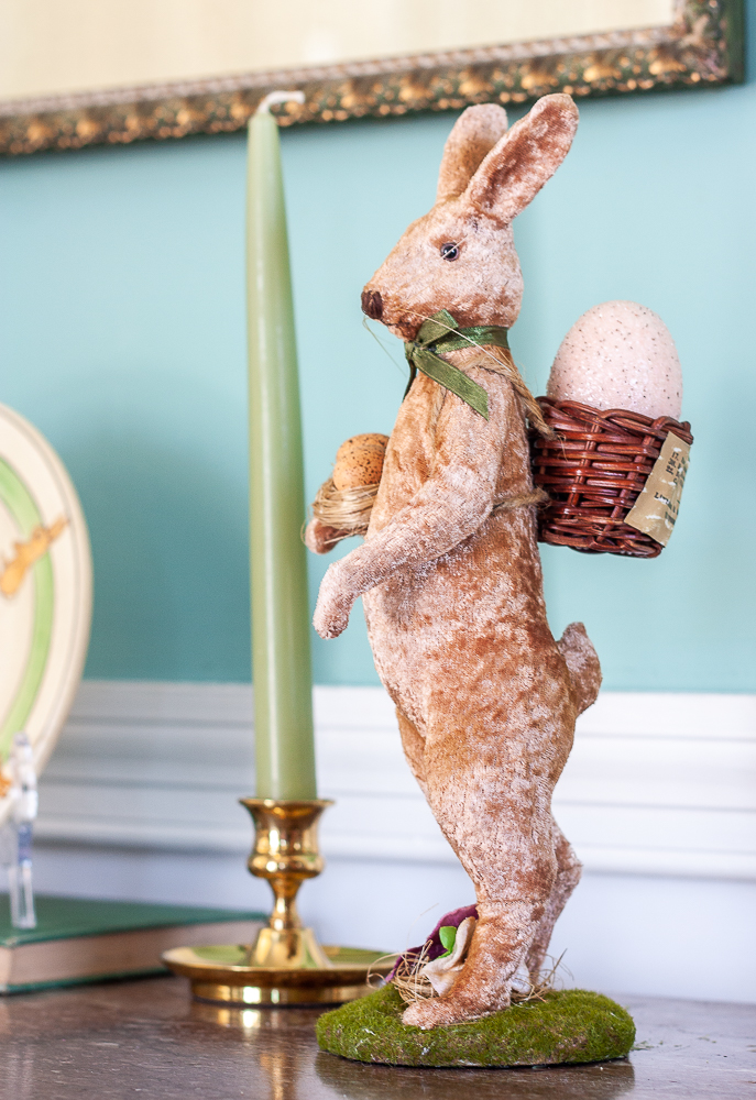 Velveteen rabbit figurine and a brass candle holder with a green candle