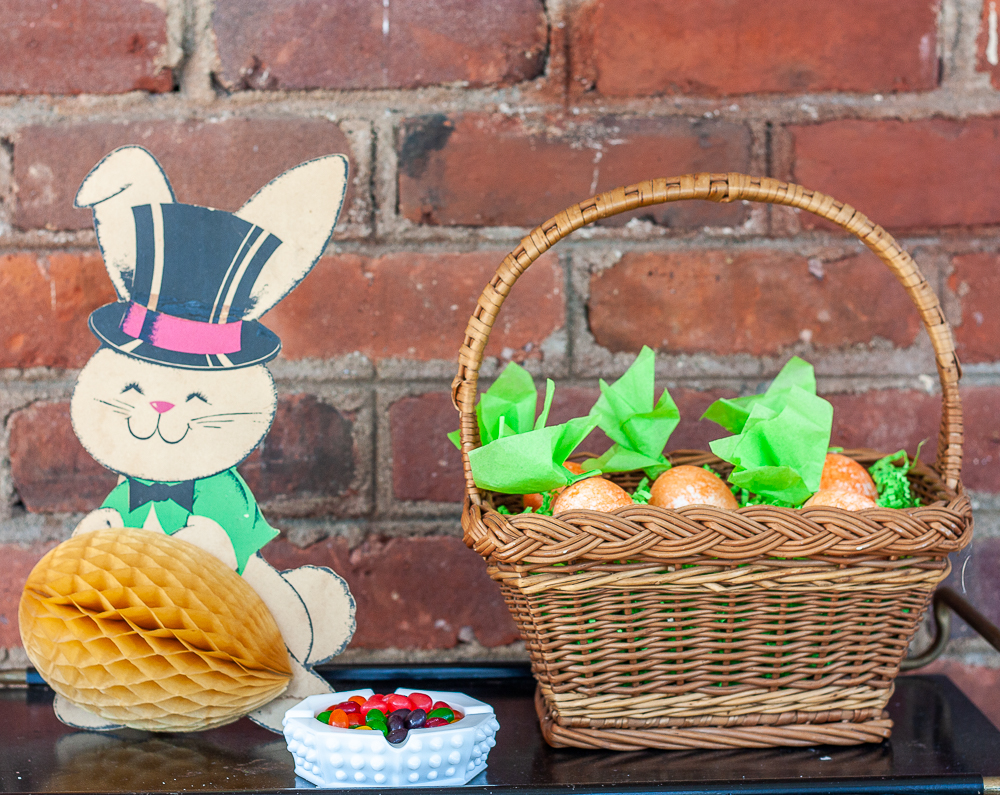 1960 paper rabbit with a fold out egg, milk glass ashtray filled with jellybeans, basket filed with carrot Easter eggs