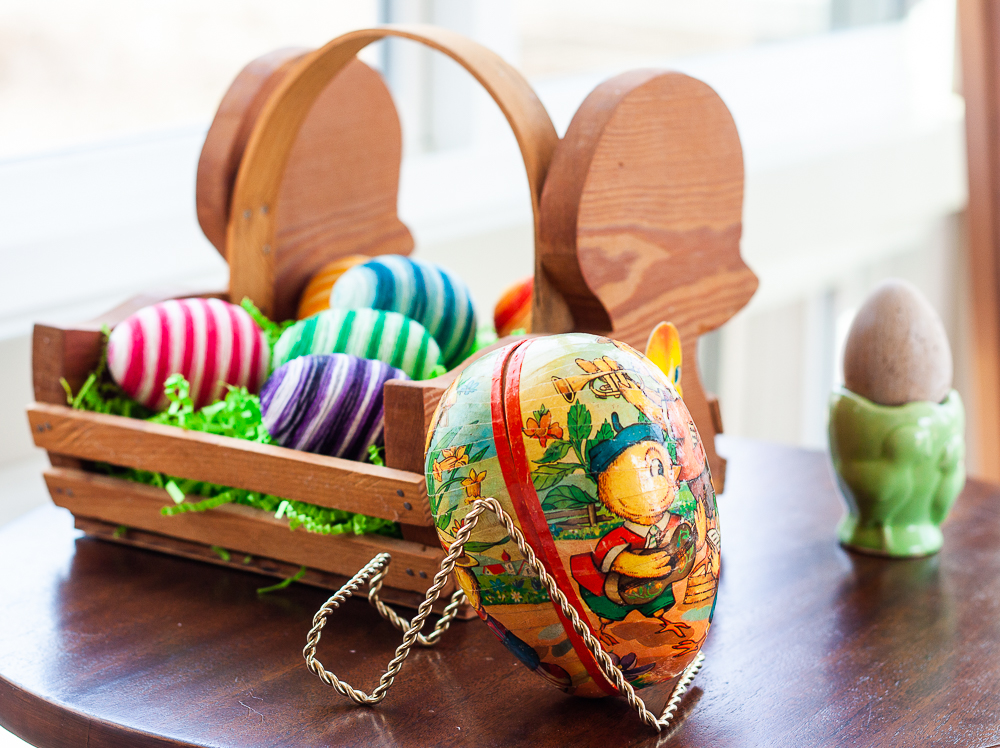 1970s paper egg with wood basket that looks like a chick filled with Easter eggs decorated with embroidery floss