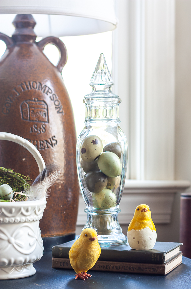 Vintage glass lidded candy holder filled with faux eggs, two chicks, two antique books