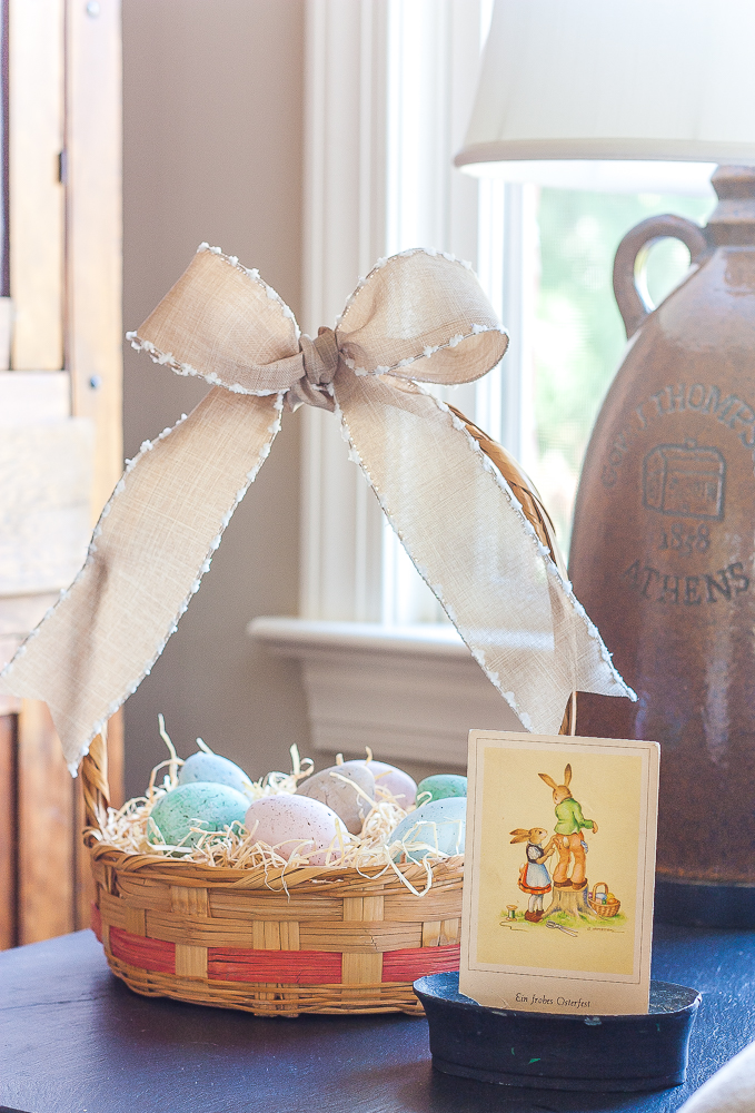 Vintage Easter basket filled with speckle painted eggs and a vintage German postcard