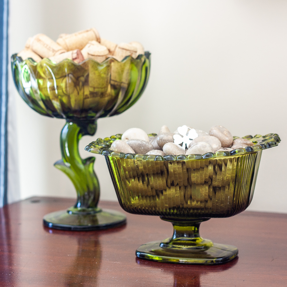 Green glass candy dishes filled with wine corks and polished stones