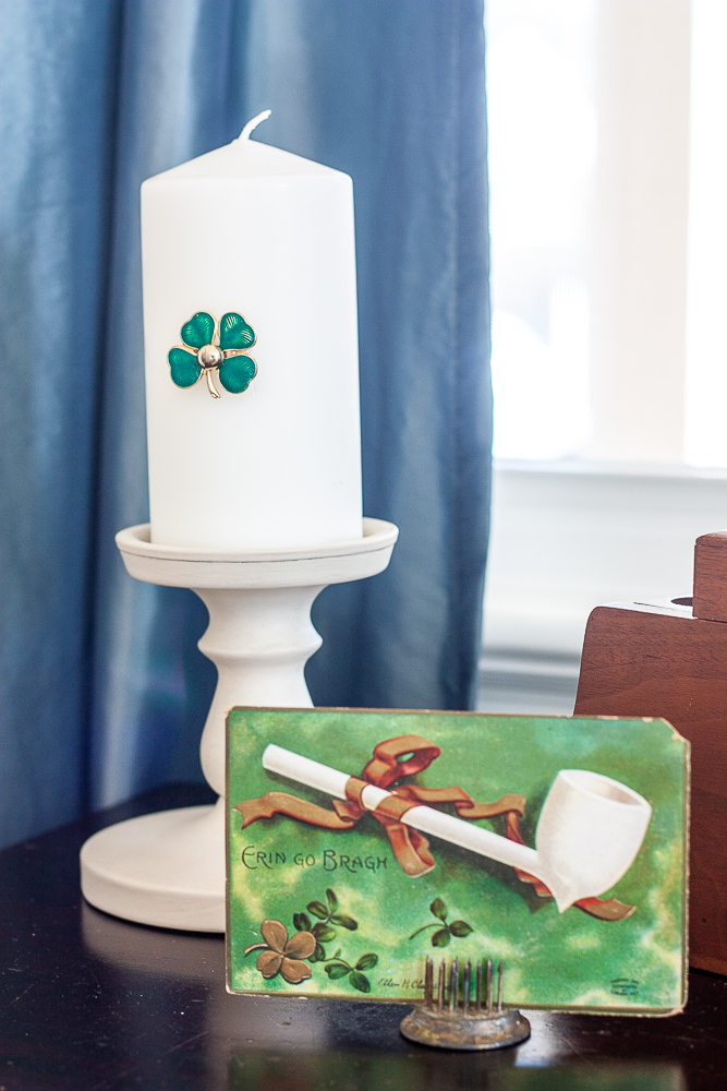 Antique St. Patrick's Day postcard and a candle on a candle holder with a green clover pin glued to it.