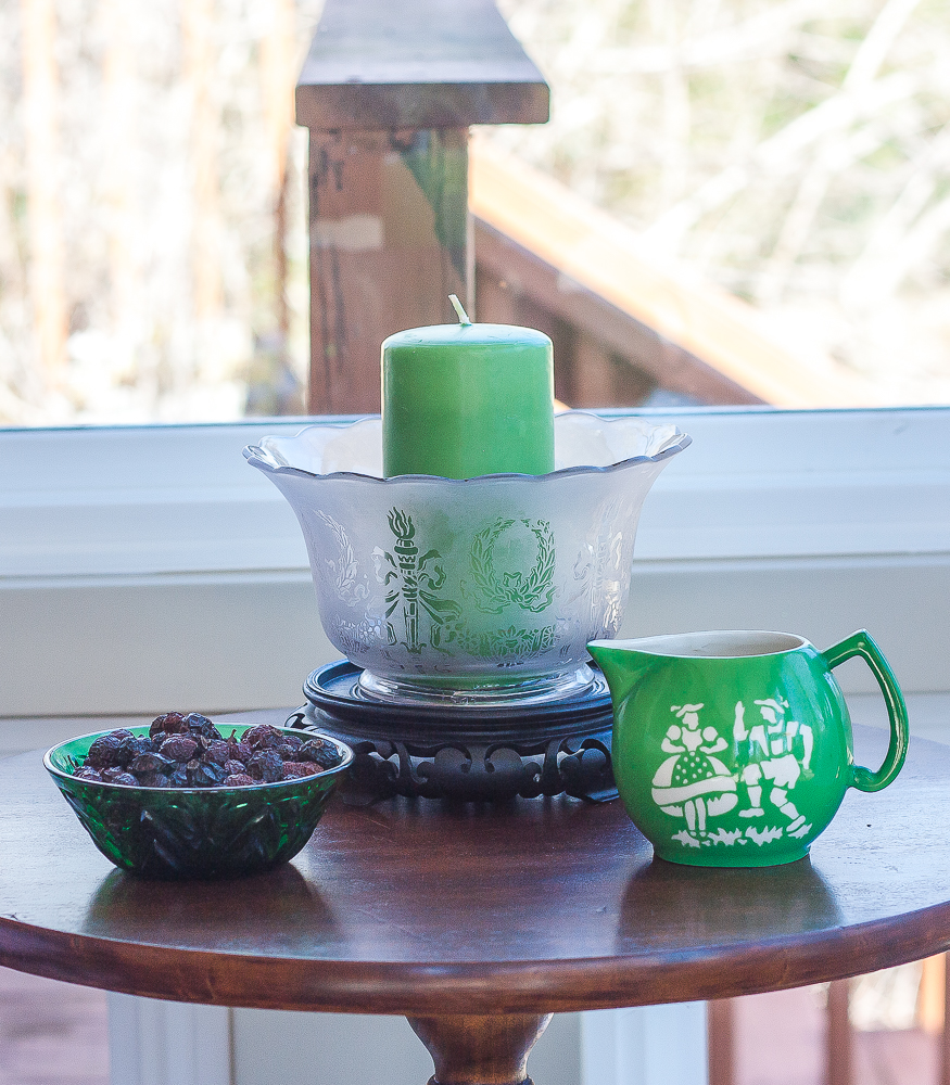Czech green pitcher, antique green glass bowl, shade from an oil lantern decorated with a candle