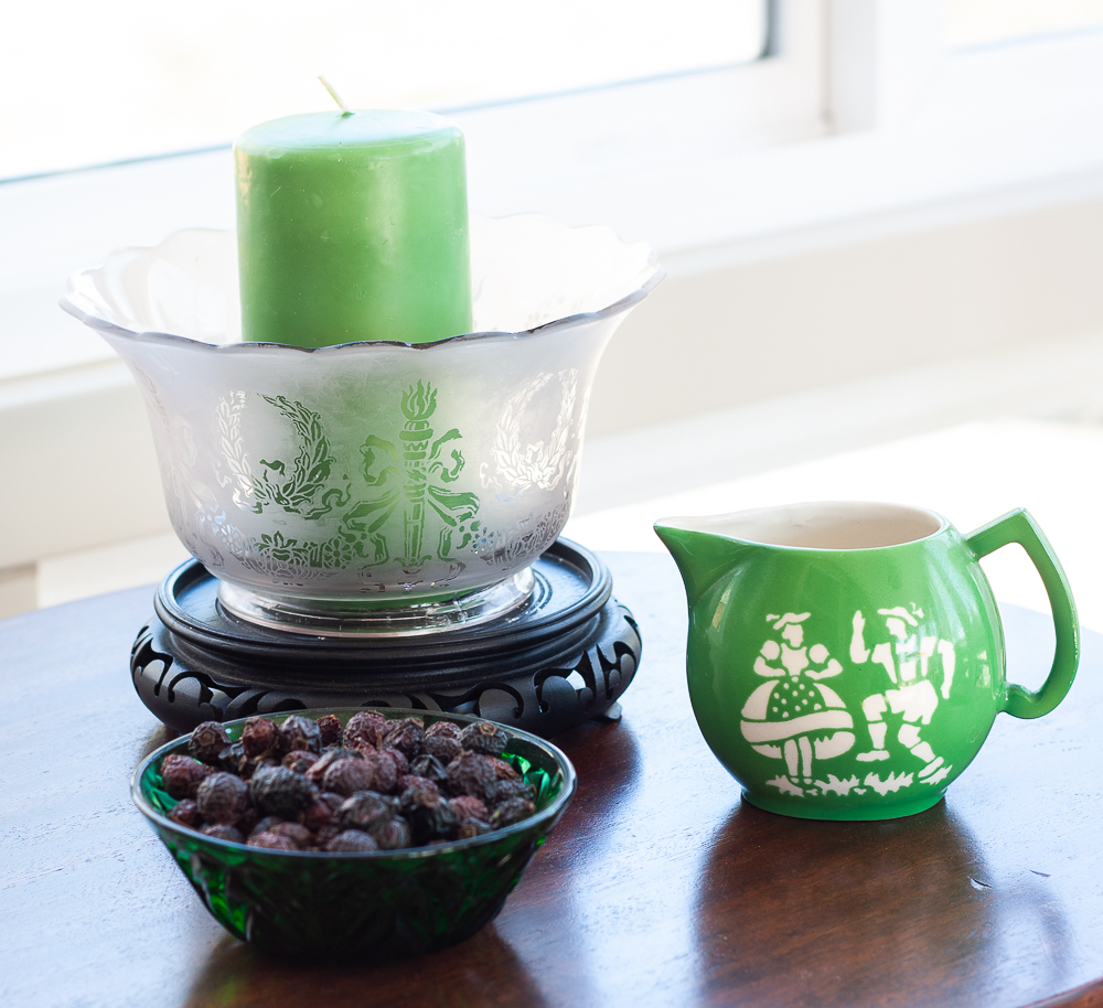 Czech green pitcher, antique green glass bowl, shade from an oil lantern decorated with a candle