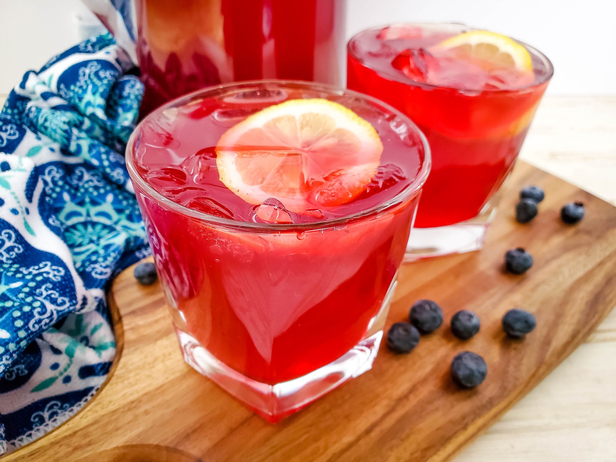 Homemade blueberry lemonade served in glasses garnished with lemons and blueberries