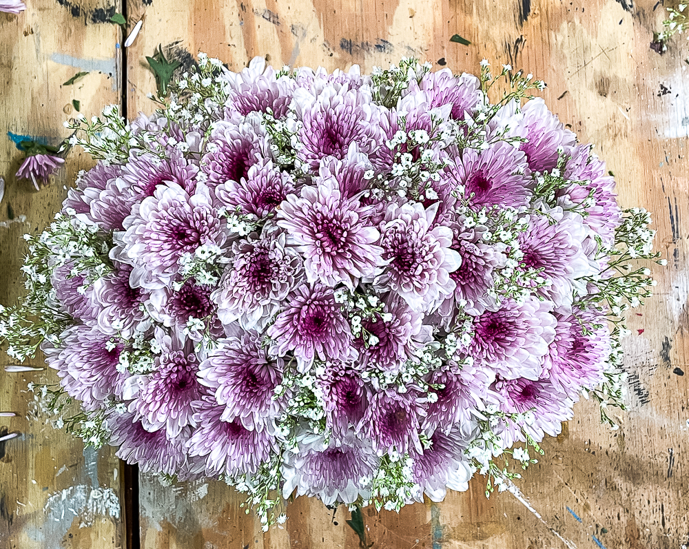 Looking down at a purple Chrysanthemum and Baby's Breath Flower arrangement