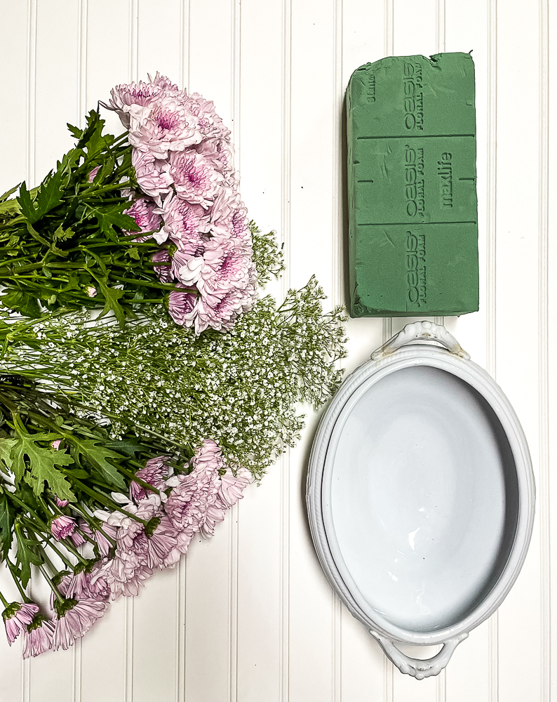 Ironstone container, floral oasis, two bunches of purple chrysanthemum and one bunch of Baby's Breath