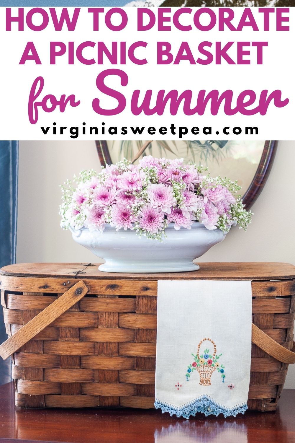 Vintage picnic basket with a floral arrangement, and vintage embroidered tea towel