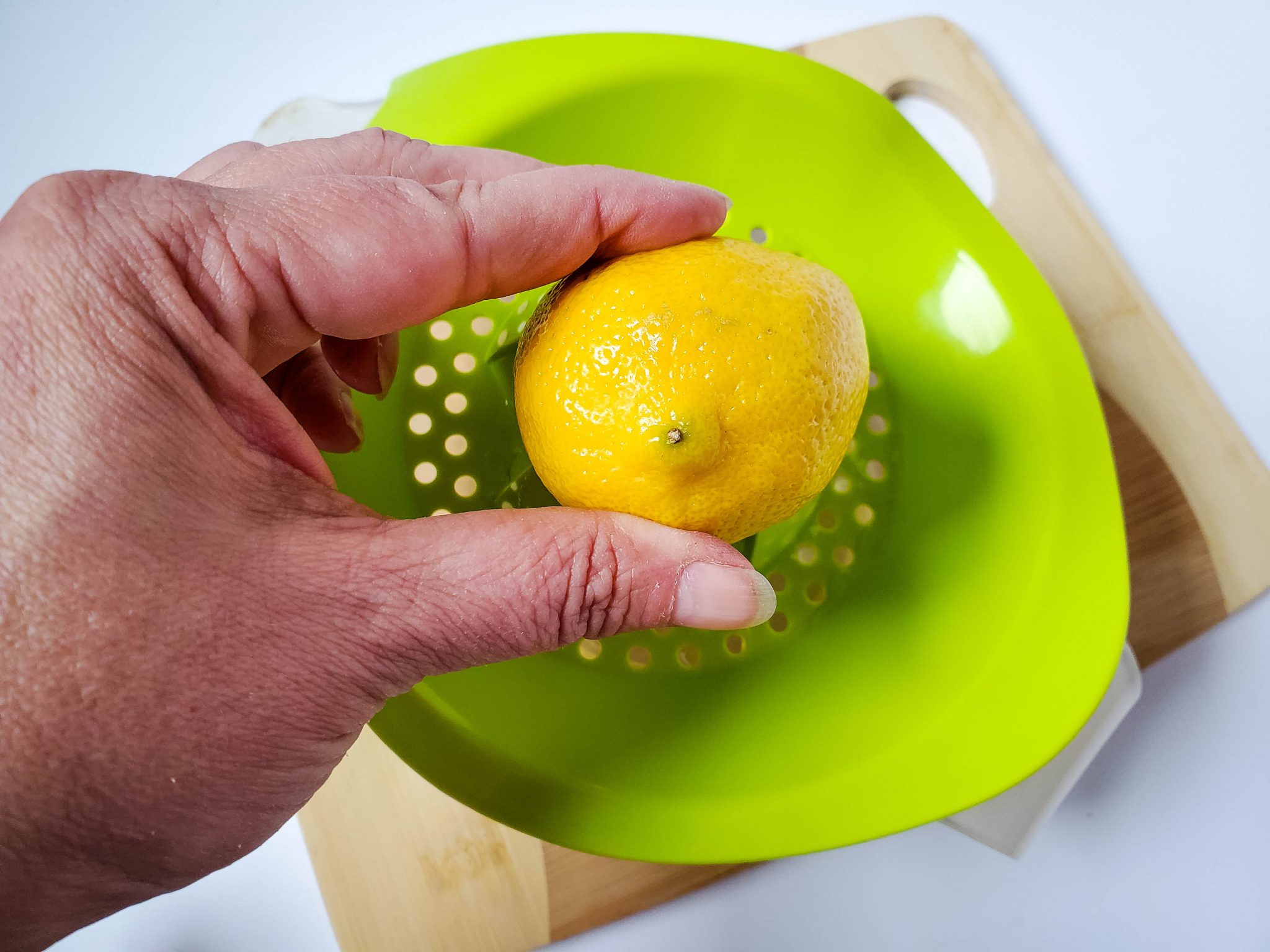 Squeezing a lemon over a strainer