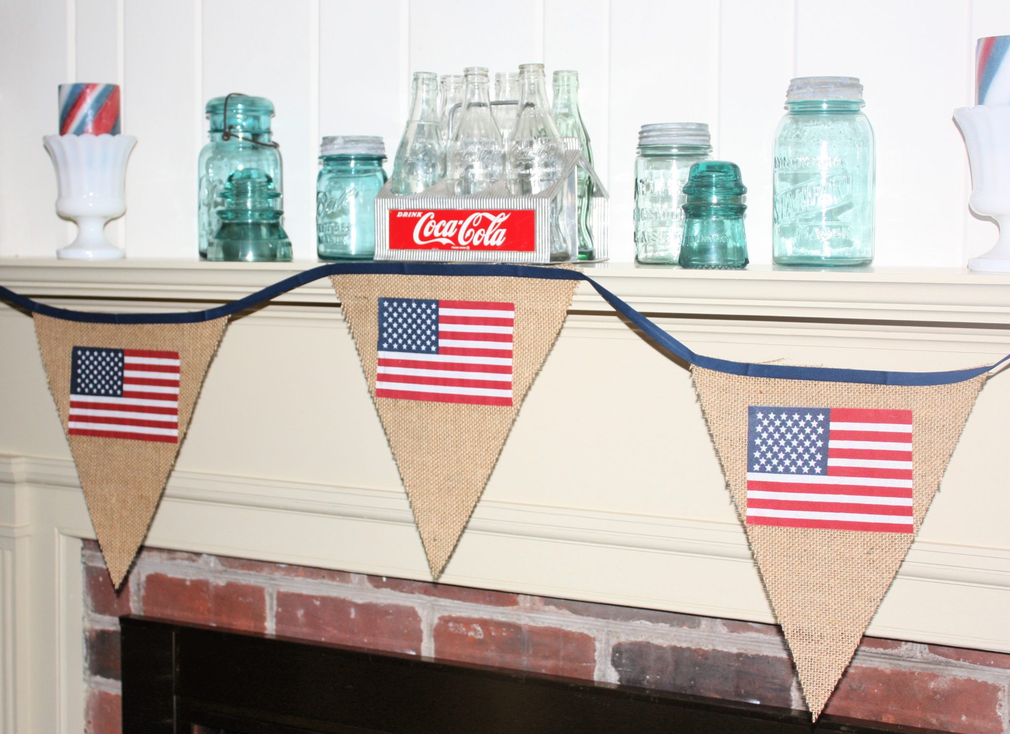 Mantel decorated for 4th of July with banner, Coke crate and bottles, vintage Mason jars