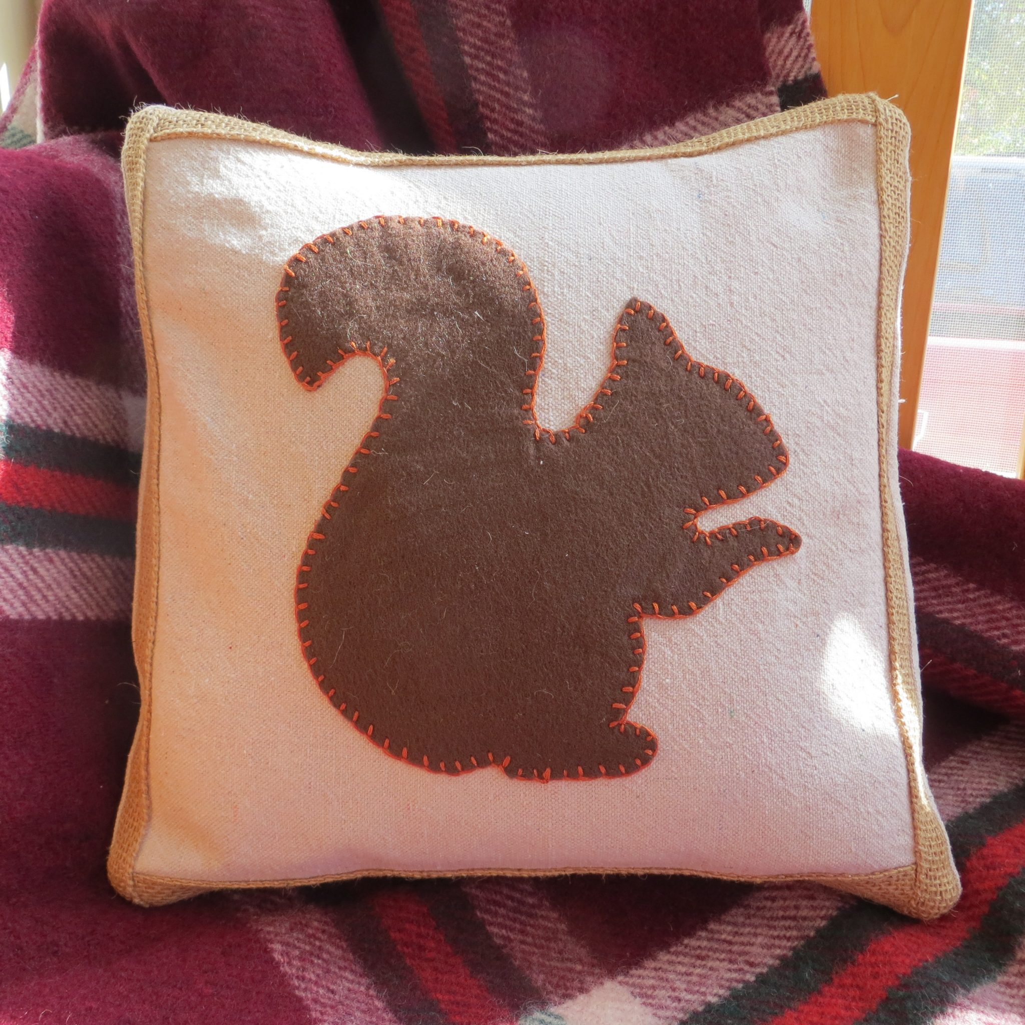 Handmade pillow with a felt squirrel