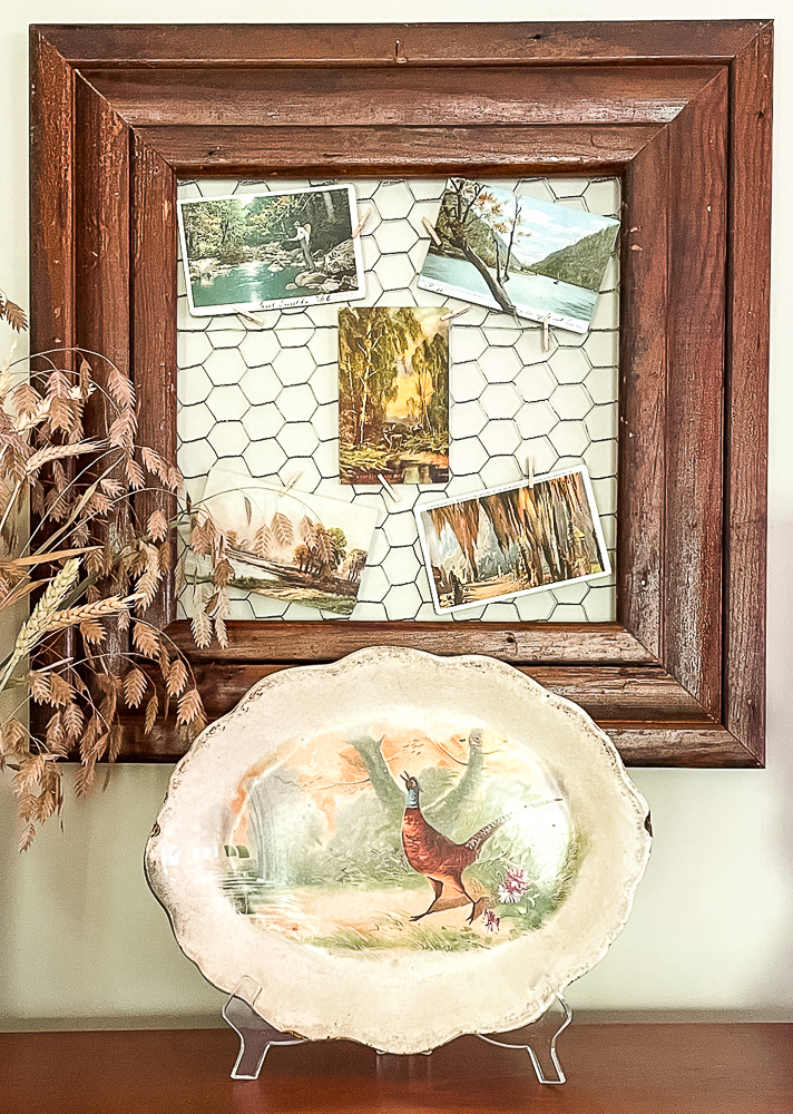 Vintage postcards displayed on chicken wire and a fall pheasant platter