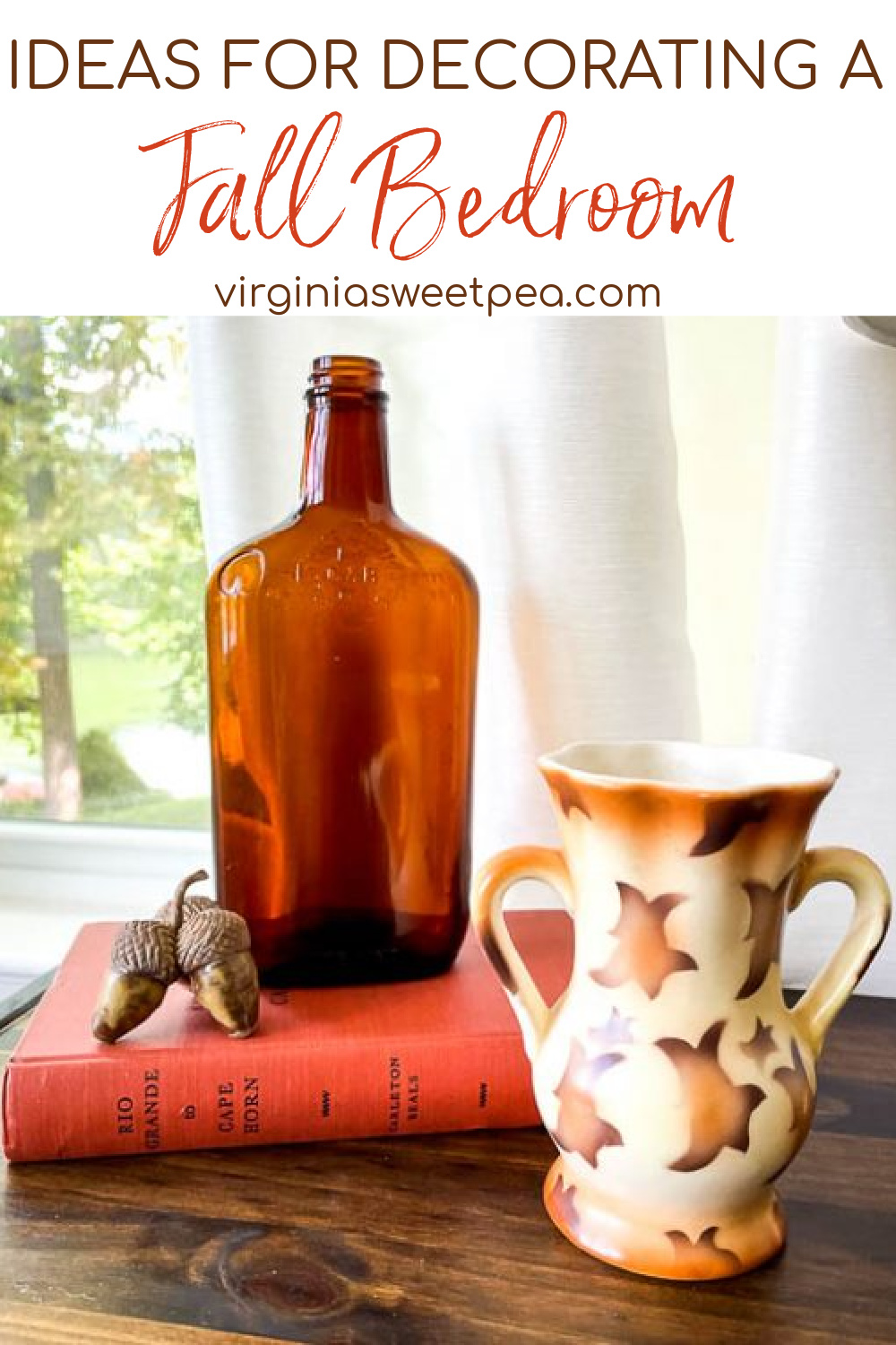 Fall vignette with a Czech vase, amber bottle, acorns and an orange book