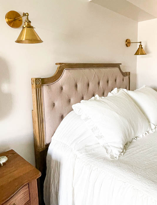 Upholstered headboard with two lights hanging over it