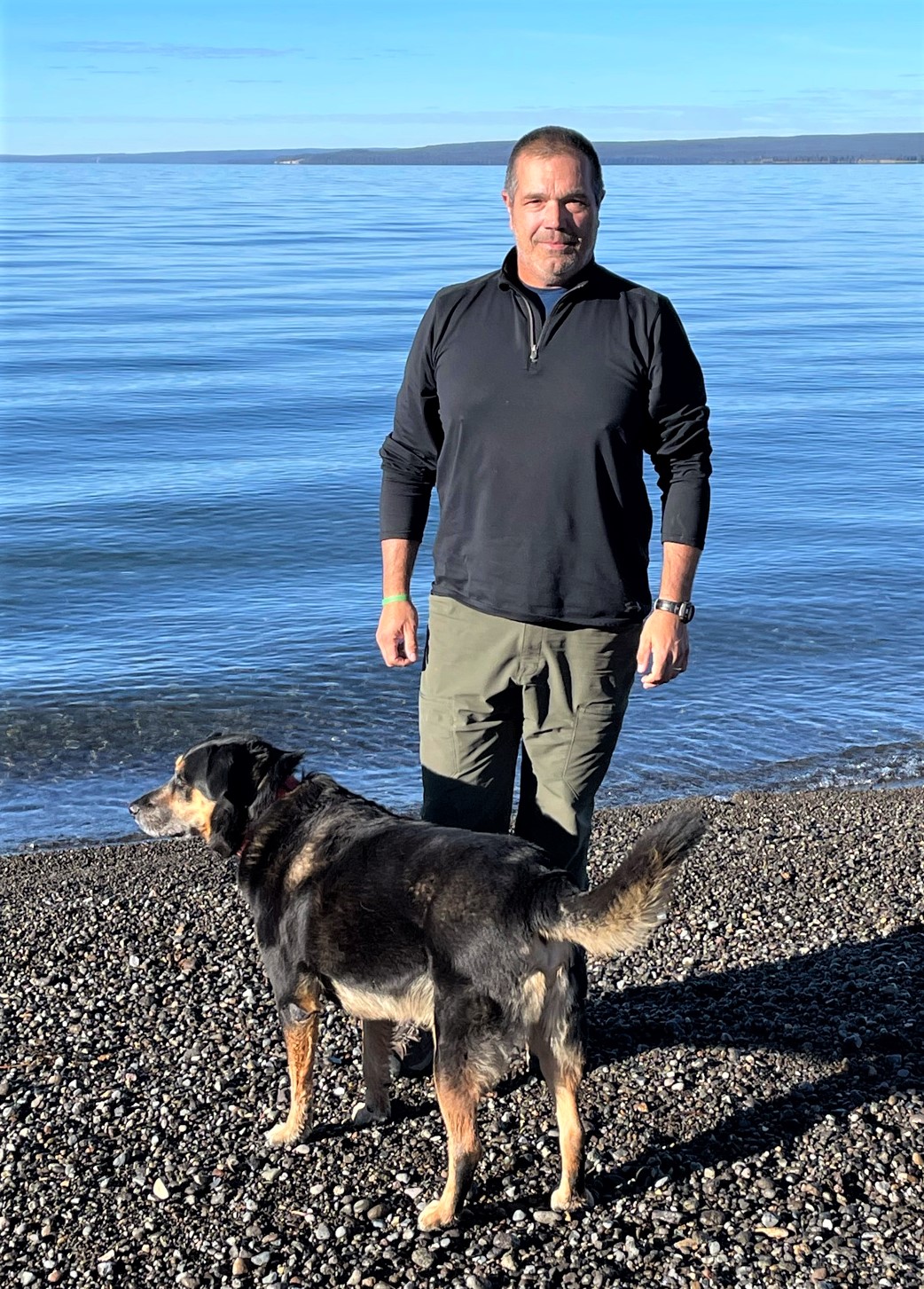 Man and dog by a lake in Yellowstone National Park