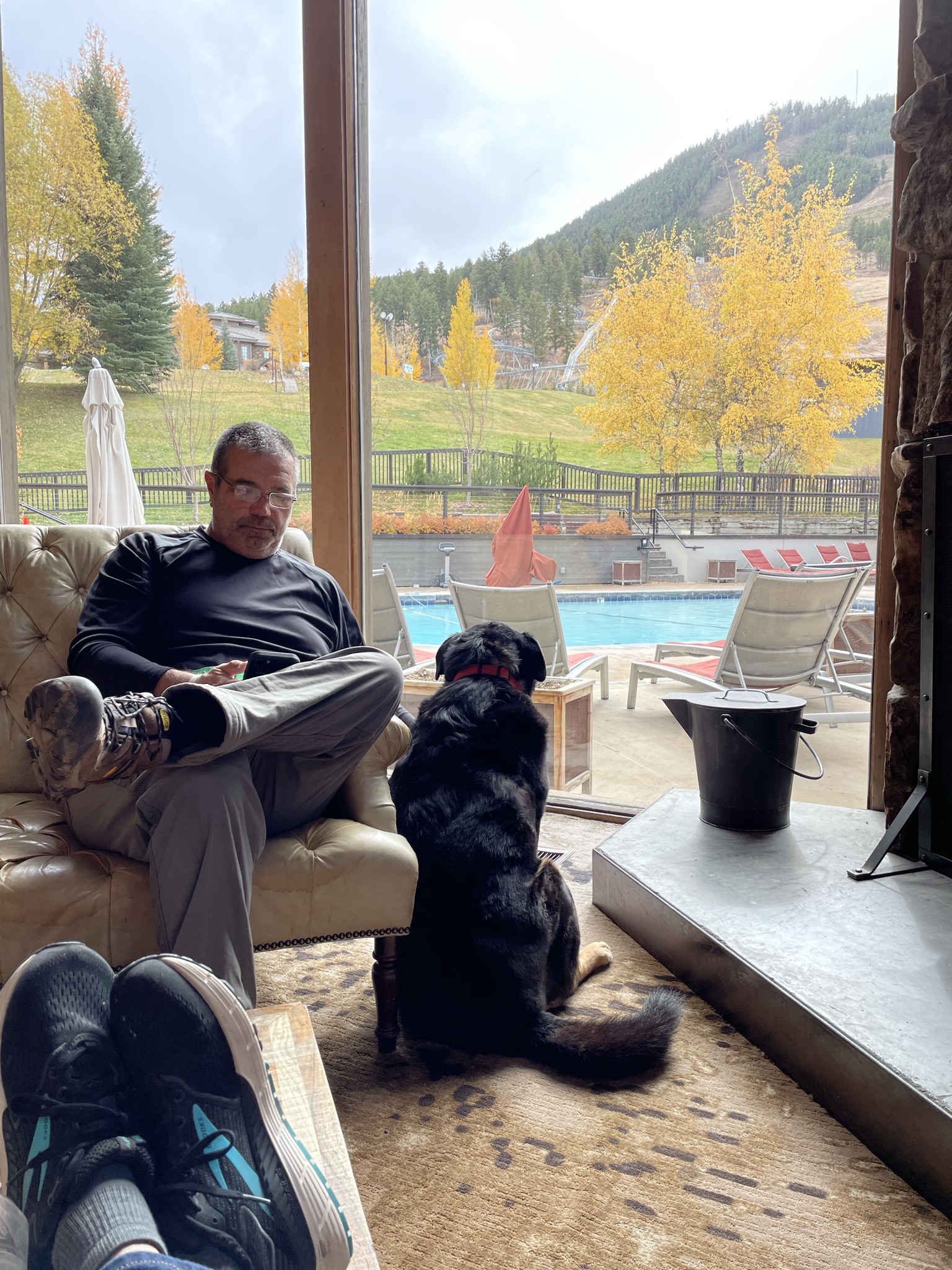 Dog and Man relaxing by the fire at Snow King Mountain Resort in Jackson Hole, Wyoming