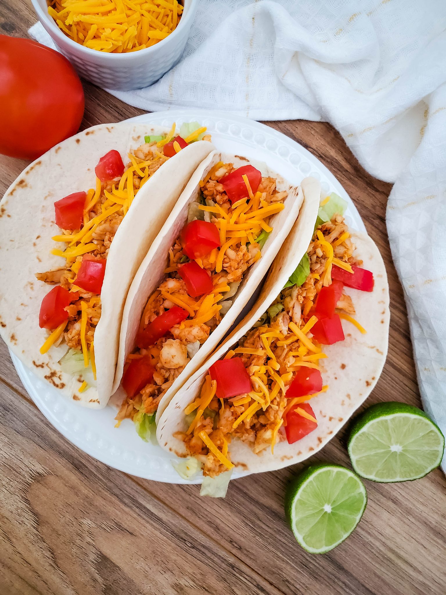 Three fish tacos on a white plate