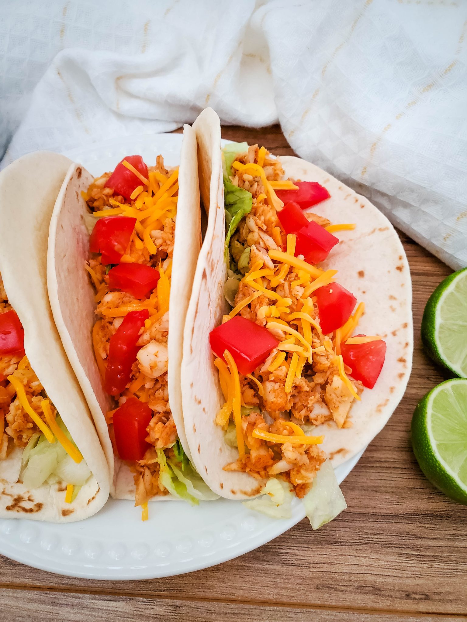 Three fish tacos on a white plate