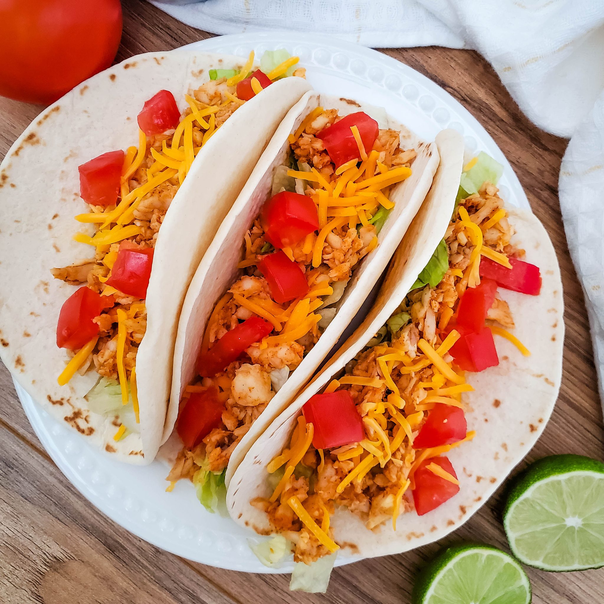 Three fish tacos on a white plate