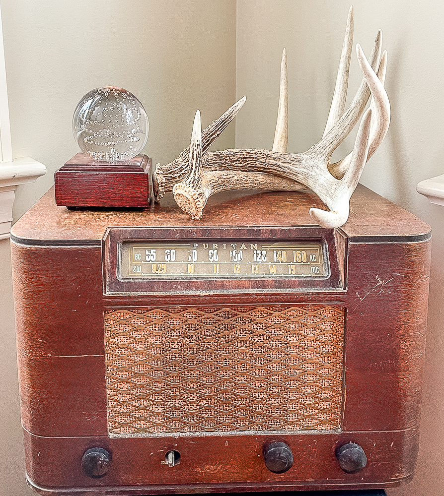 deer antlers displayed on a vintage radio